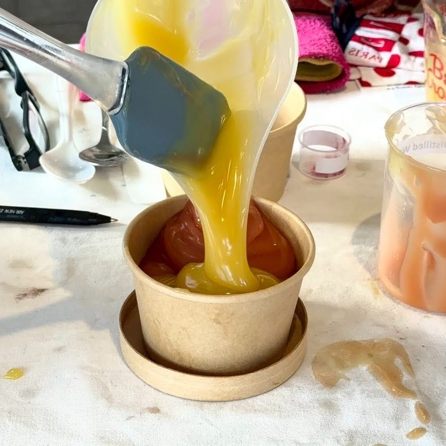 Pouring bright yellow soap batter into a mould